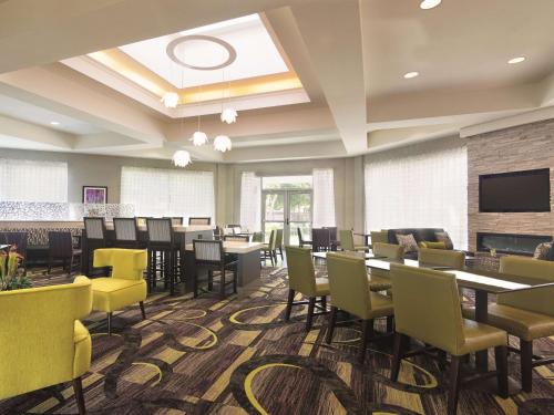 a dining room with tables and chairs and a tv at La Quinta by Wyndham Oklahoma City Norman in Norman