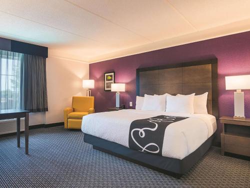 a hotel room with a large bed and a chair at La Quinta by Wyndham Atlanta Conyers in Conyers