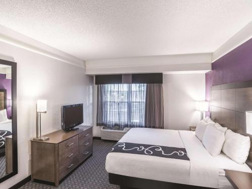 a hotel room with a bed and a flat screen tv at La Quinta by Wyndham Flagstaff in Flagstaff