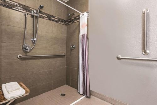 a bathroom with a shower with a shower curtain at La Quinta by Wyndham Orlando Lake Mary in Lake Mary