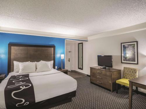 a hotel room with a bed and a desk and a television at La Quinta by Wyndham Phoenix Chandler in Phoenix