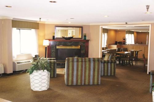 a living room with chairs and a fire place at La Quinta Inn by Wyndham Kansas City North in Kansas City