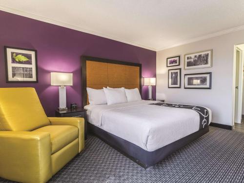 a hotel room with a bed and a yellow chair at La Quinta by Wyndham Phoenix Scottsdale in Scottsdale