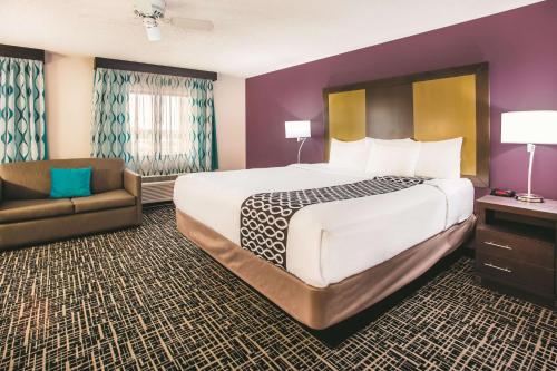 a hotel room with a large bed and a chair at La Quinta by Wyndham Cincinnati NE - Mason in Mason