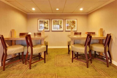 a waiting room with tables and chairs in a room at La Quinta by Wyndham Plattsburgh in Plattsburgh