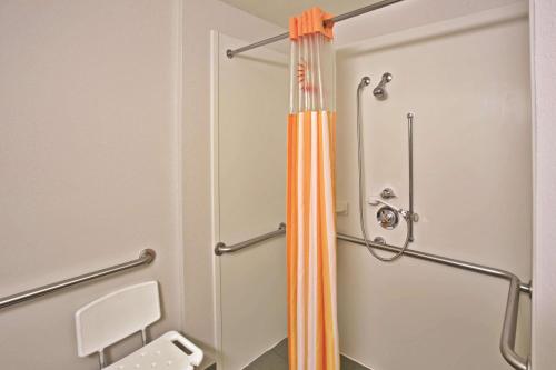 伯明翰的住宿－伯明翰霍姆伍德拉昆塔套房酒店，浴室内带橙色淋浴帘的淋浴间
