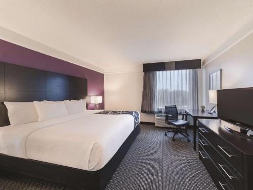 a hotel room with a large bed and a desk at La Quinta by Wyndham Austin Round Rock in Round Rock