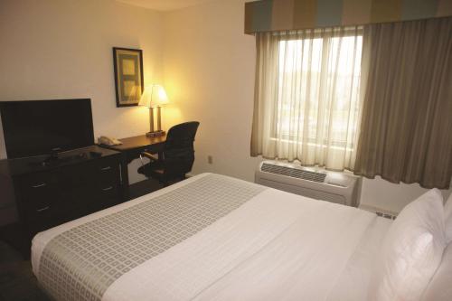 a hotel room with a bed and a desk and a television at La Quinta by Wyndham Boston Somerville in Somerville
