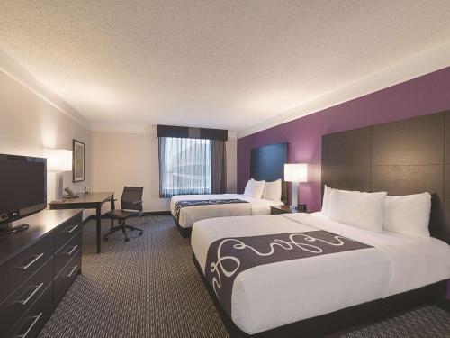a hotel room with two beds and a flat screen tv at La Quinta by Wyndham Austin Round Rock in Round Rock
