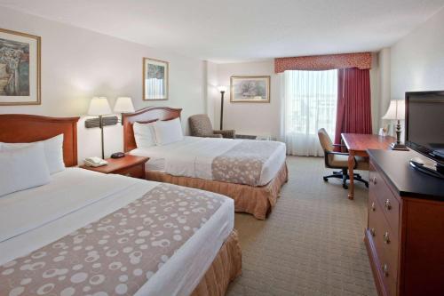 a hotel room with two beds and a desk at La Quinta by Wyndham Downtown Conference Center in Little Rock