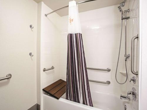 a bathroom with a shower and a tub at La Quinta by Wyndham Baltimore N / White Marsh in Baltimore