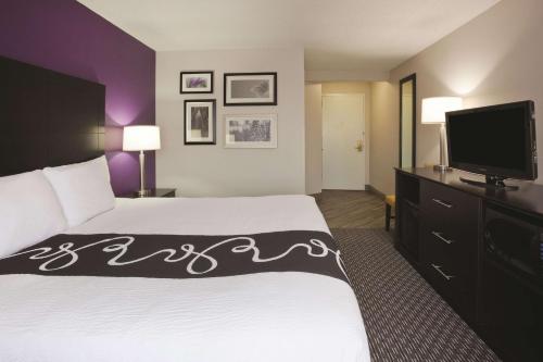 a hotel room with a bed and a flat screen tv at La Quinta by Wyndham Minneapolis Bloomington W - FREE AIRPORT SHUTTLE in Bloomington