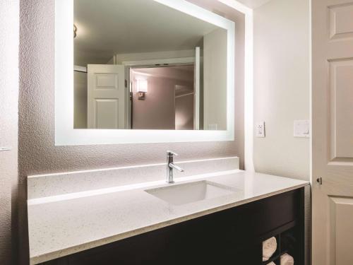 a bathroom with a mirror and a sink at La Quinta by Wyndham Alexandria Airport in Alexandria