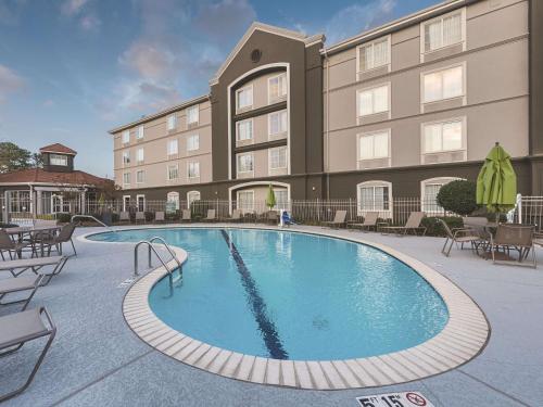 a hotel with a large swimming pool in front of a building at La Quinta by Wyndham Shreveport Airport in Shreveport