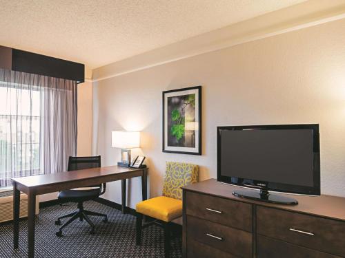 a hotel room with a desk and a television at La Quinta by Wyndham Denver Airport DIA in Denver