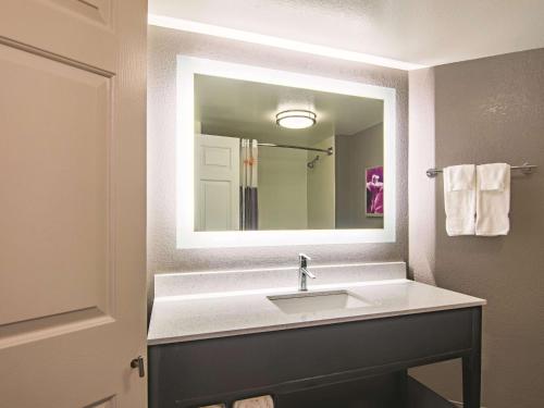 a bathroom with a sink and a large mirror at La Quinta by Wyndham Oklahoma City Norman in Norman