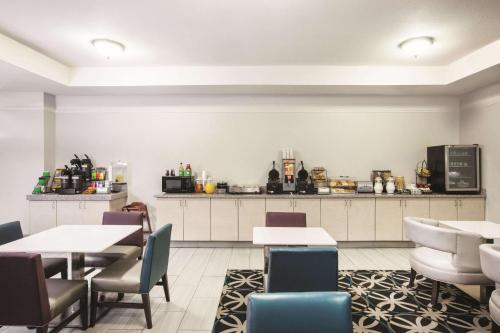 a restaurant with tables and chairs and a kitchen at La Quinta by Wyndham Mansfield TX in Mansfield