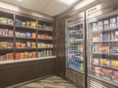 a grocery store aisle with a refrigerator and food at La Quinta by Wyndham Oklahoma City Norman in Norman