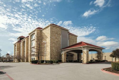 a large brick building with a gazebo in a parking lot at La Quinta by Wyndham Mansfield TX in Mansfield