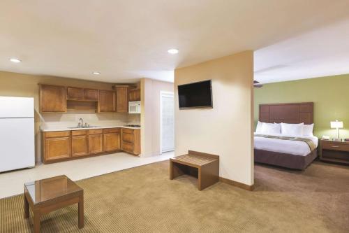 a hotel room with a bed and a kitchen at La Quinta Inn by Wyndham Austin North in Austin