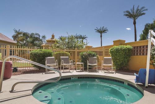 a small swimming pool with chairs and a fence at La Quinta by Wyndham Phoenix Mesa West in Mesa