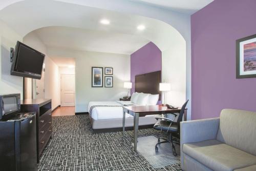 a hotel room with a bed and a desk at La Quinta by Wyndham Fort Walton Beach in Fort Walton Beach
