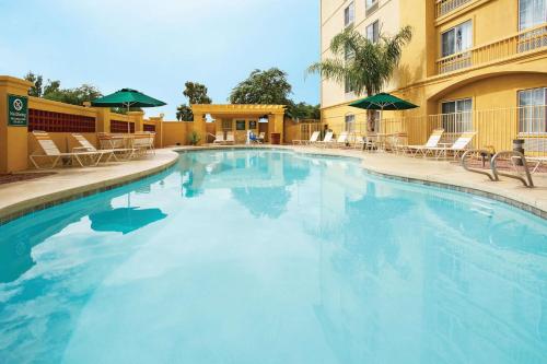 a large swimming pool with chairs and a building at La Quinta by Wyndham Mesa Superstition Springs in Mesa