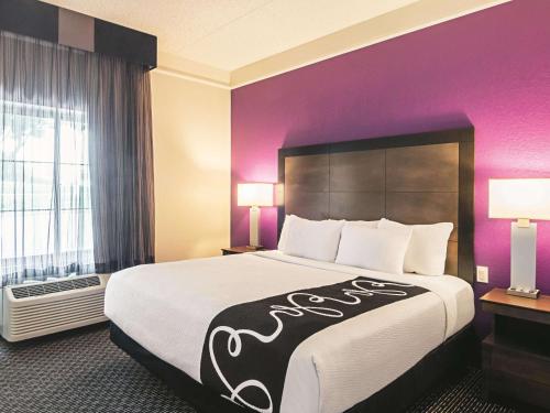 a large bed in a hotel room with purple walls at La Quinta by Wyndham Denver Airport DIA in Denver