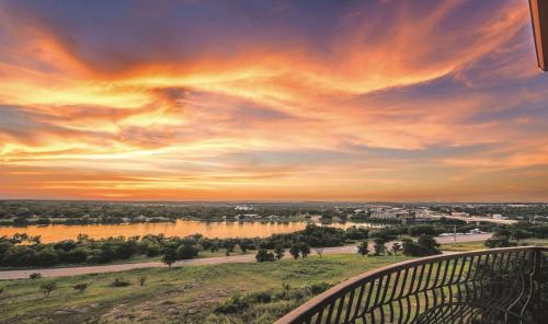 a view of a river at sunset from a balcony at La Quinta by Wyndham Marble Falls in Marble Falls