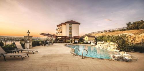 a hotel with a swimming pool in front of a building at La Quinta by Wyndham Marble Falls in Marble Falls