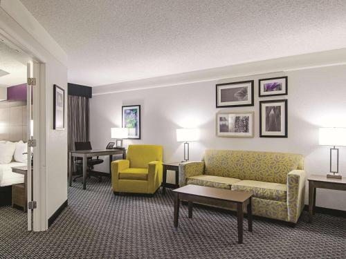 a hotel room with a couch and a chair at La Quinta by Wyndham Denver Airport DIA in Denver