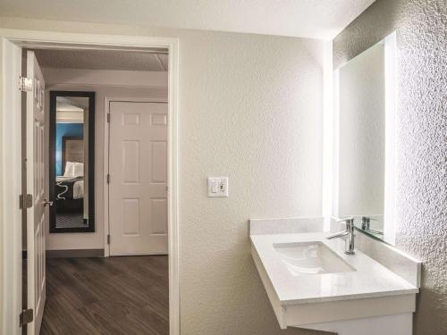 a white bathroom with a sink and a mirror at La Quinta by Wyndham Phoenix Chandler in Phoenix