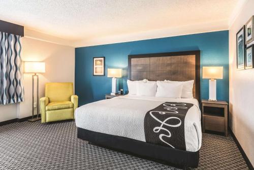 a hotel room with a bed and a chair at La Quinta by Wyndham Orlando Lake Mary in Lake Mary