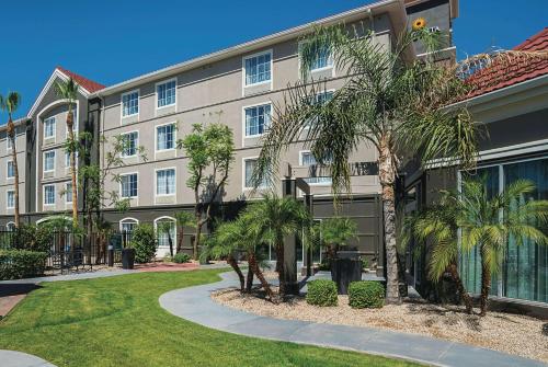 a building with palm trees in front of it at La Quinta by Wyndham Phoenix Chandler in Phoenix