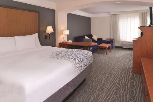 a hotel room with a bed and a living room at La Quinta by Wyndham Ruidoso Downs in Ruidoso Downs