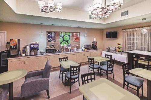 a restaurant with tables and chairs and a bar at La Quinta by Wyndham Corpus Christi Northwest in Corpus Christi