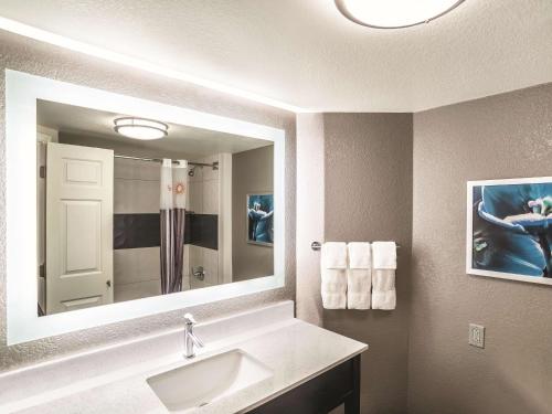 a bathroom with a sink and a large mirror at La Quinta by Wyndham Phoenix Chandler in Phoenix