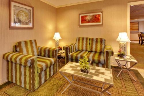 a living room with two chairs and a table at La Quinta by Wyndham Plattsburgh in Plattsburgh