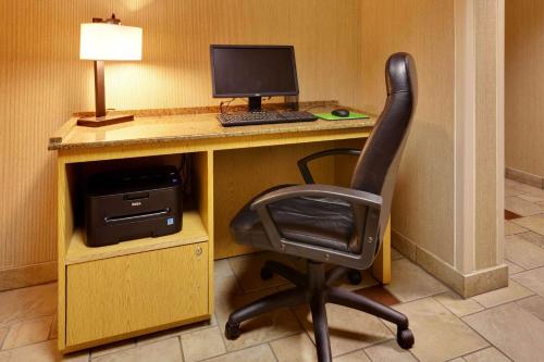 a desk with a computer and a chair in a room at La Quinta by Wyndham Plattsburgh in Plattsburgh