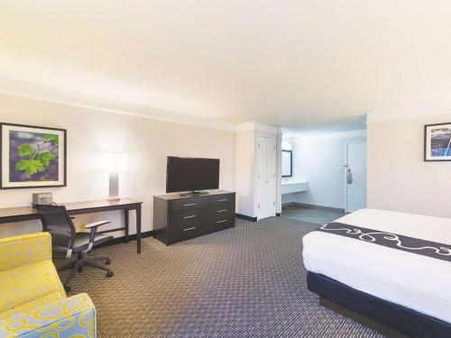 a hotel room with a bed and a desk with a computer at La Quinta by Wyndham Austin Round Rock in Round Rock