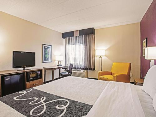 a hotel room with a bed and a flat screen tv at La Quinta by Wyndham Baltimore N / White Marsh in Baltimore