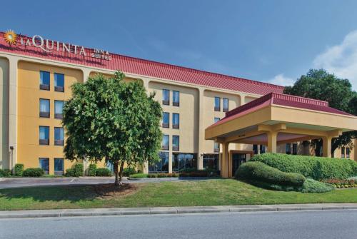 un hotel con un árbol frente a un edificio en La Quinta by Wyndham Charleston Riverview en Charleston