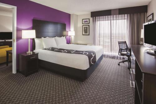 um quarto de hotel com uma cama grande e paredes roxas em La Quinta by Wyndham Minneapolis Bloomington W em Bloomington