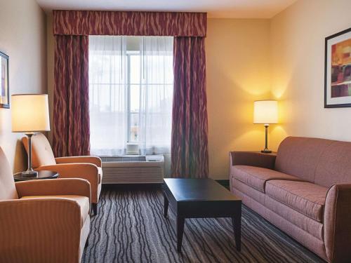 a hotel room with a couch and a window at La Quinta by Wyndham Slidell - North Shore Area in Slidell