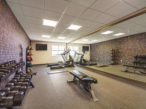 a gym with several tread machines and a mirror at La Quinta by Wyndham McKinney in McKinney