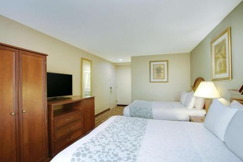 a hotel room with two beds and a flat screen tv at La Quinta Inn by Wyndham Queens (New York City) in Queens