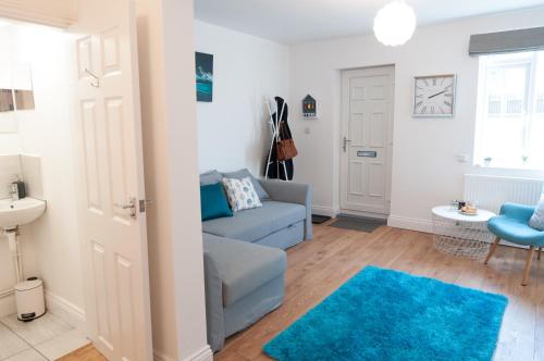 een woonkamer met een blauwe bank en een blauw tapijt bij The Wellington - Ideal for Professionals in Burton upon Trent