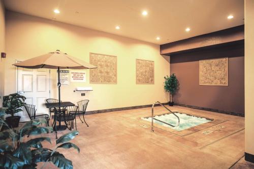 a room with a table and an umbrella and a pool at La Quinta by Wyndham Marble Falls in Marble Falls