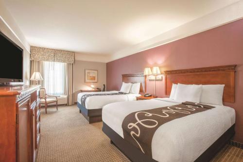 a hotel room with two beds and a flat screen tv at La Quinta by Wyndham Gainesville in Gainesville