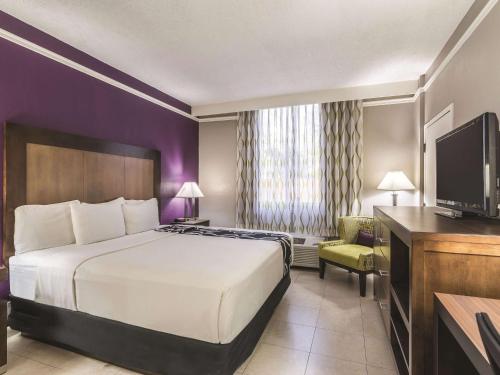 a hotel room with a bed and a tv at La Quinta Inn by Wyndham Jupiter in Jupiter